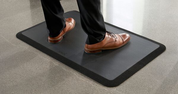 individual standing on mat